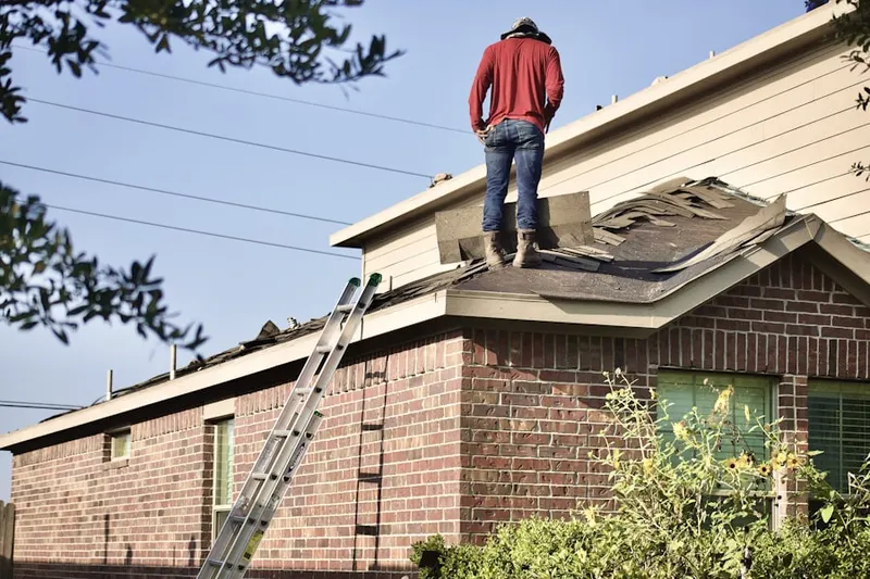 Professional roofer working on a residential roof in Curtis